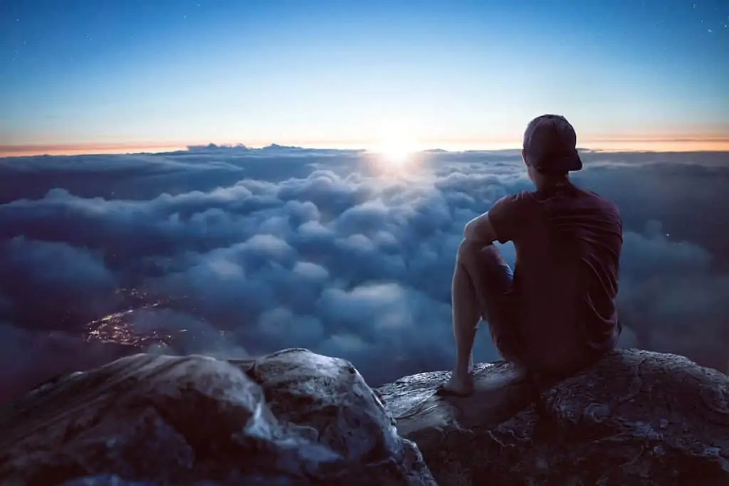 man sitting above the clouds