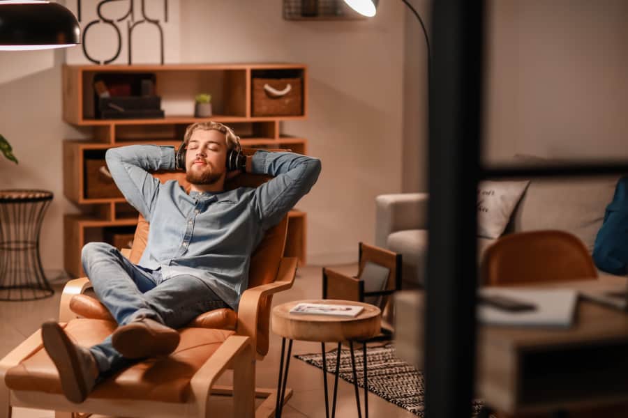 man relaxing in chair wearing headphones