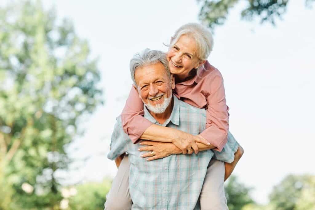 senior couple piggy back ride