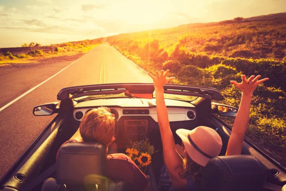 Couple-Driving-Convertable-at-Sunset- Couple Driving Convertable at Sunset