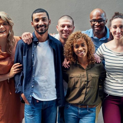 Were one happy team. Portrait of a group of people standing together against a wall outside